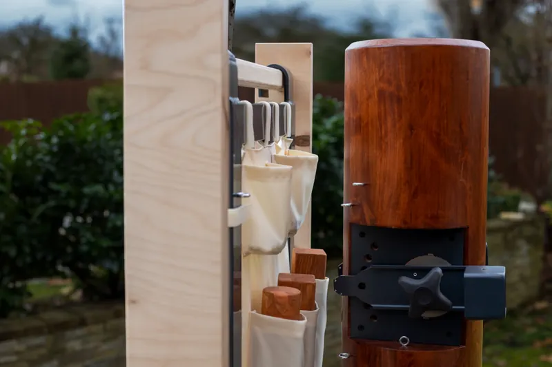 Parts pouch with arms hanging on the wall bar next to the Wooden Buddy body